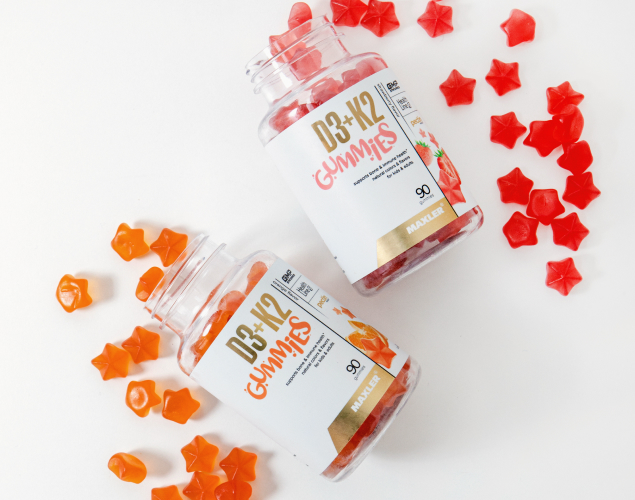 A photo of an orange and a strawberry D3 K2 gummies bottles.