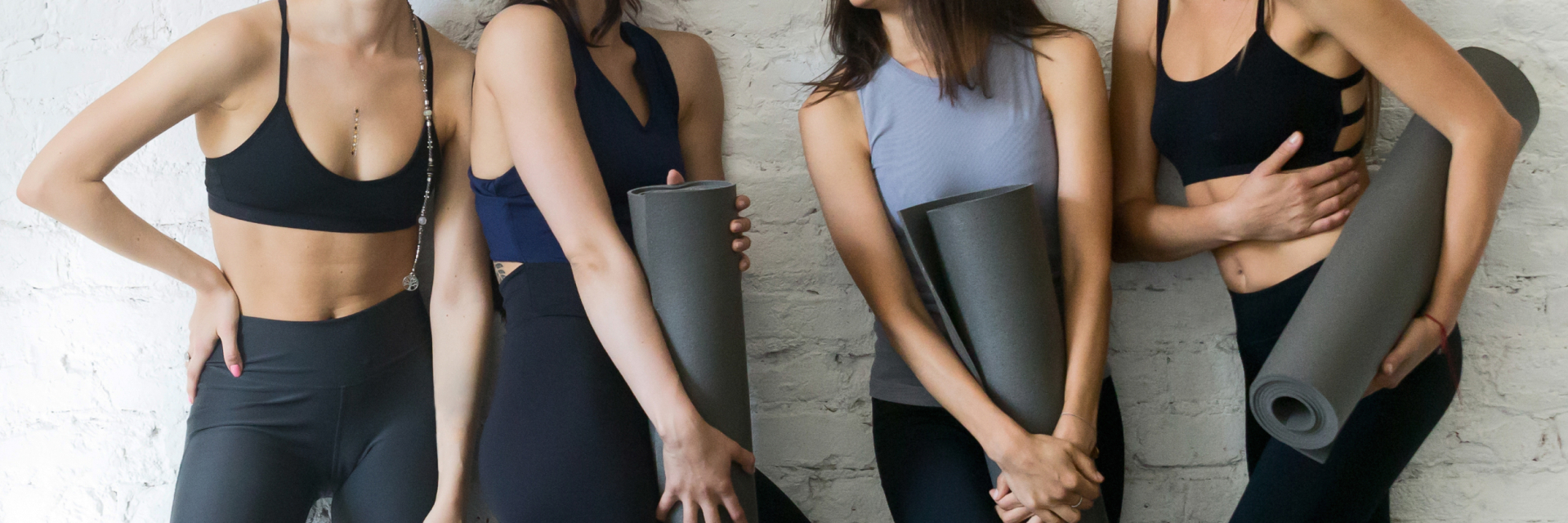 A photo of women with yoga mats.