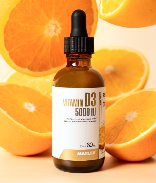 Maxler Vitamin D3 5000 IU liquid supplement bottle placed among fresh oranges, highlighting its natural orange flavor and immune support benefits