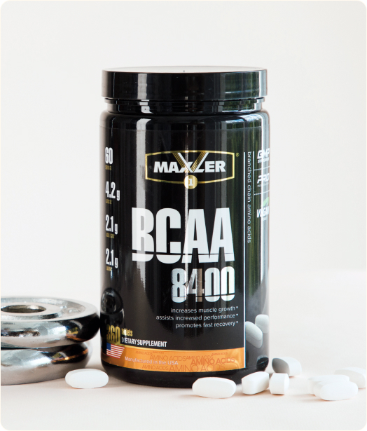 A photo of BCAA 8400 container with few tablets near it.