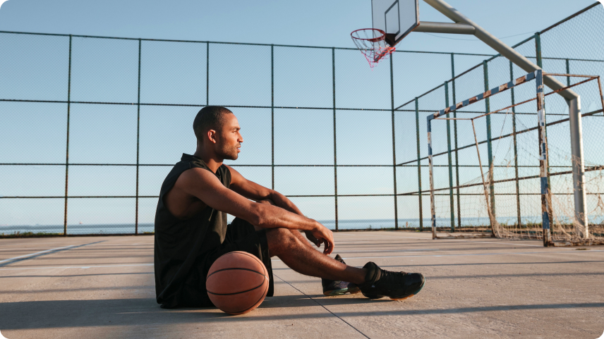 A man sitting with a basketball ball