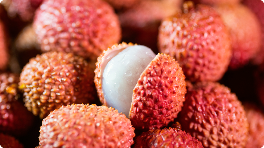 Fresh lychees with one peeled open, highlighting this tropical fruit as a source of vitamin C