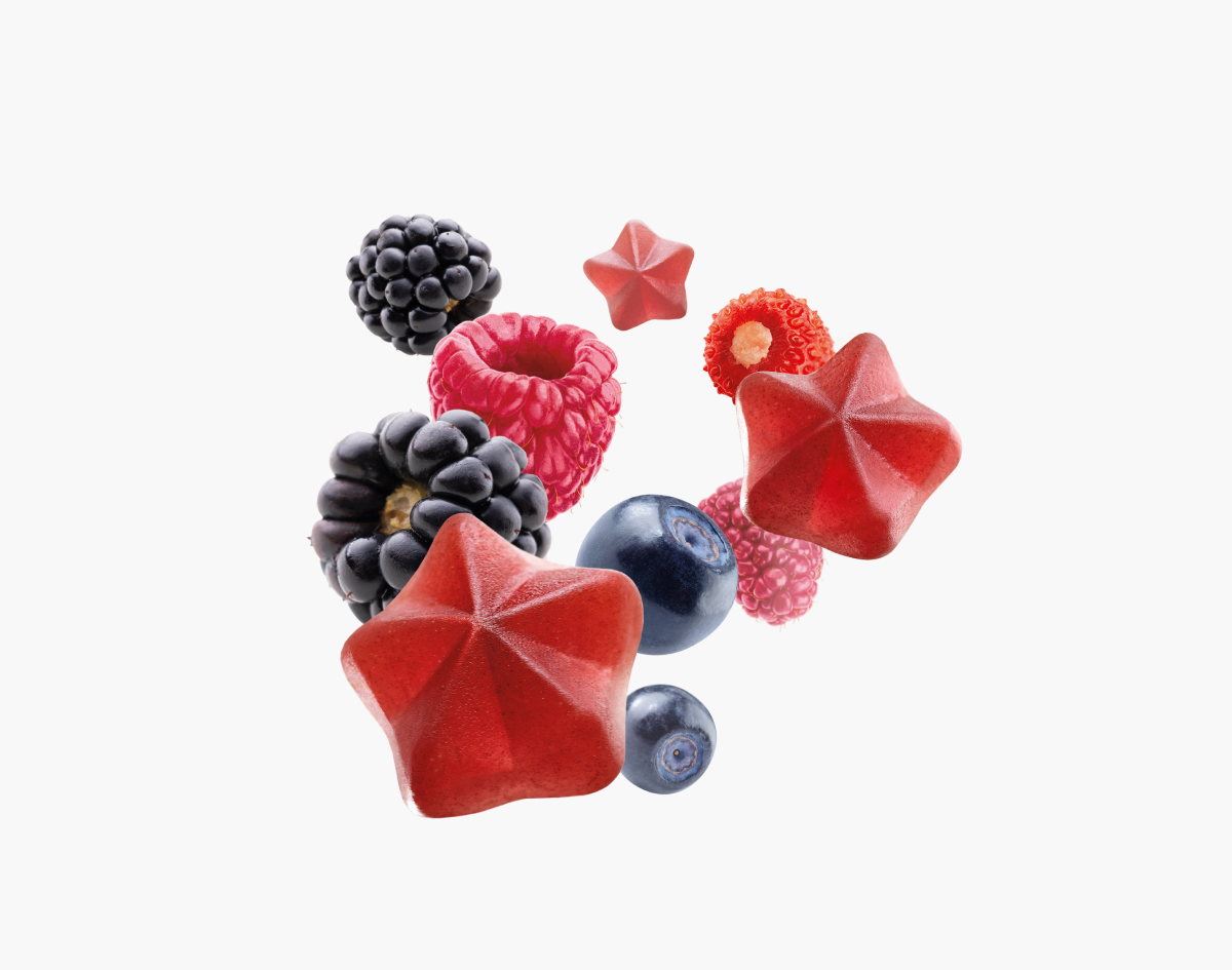 Close-up of fresh berries and red star-shaped gummies, highlighting Maxler Iron Plus Gummies' natural ingredients.